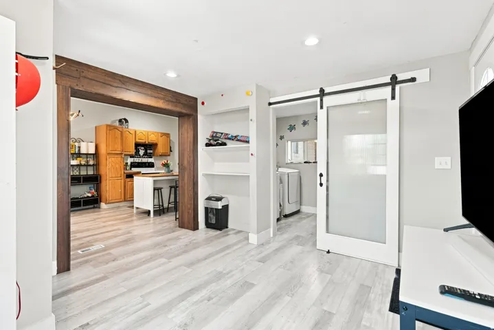 Wood-finish flooring throughout, with a wide cased opening featuring wood-finish beams