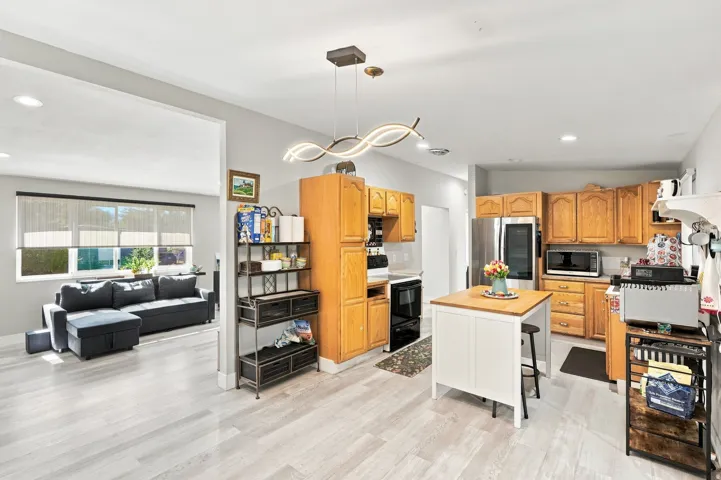 Kitchen with wood cabinetry, stainless steel appliances, and a central island