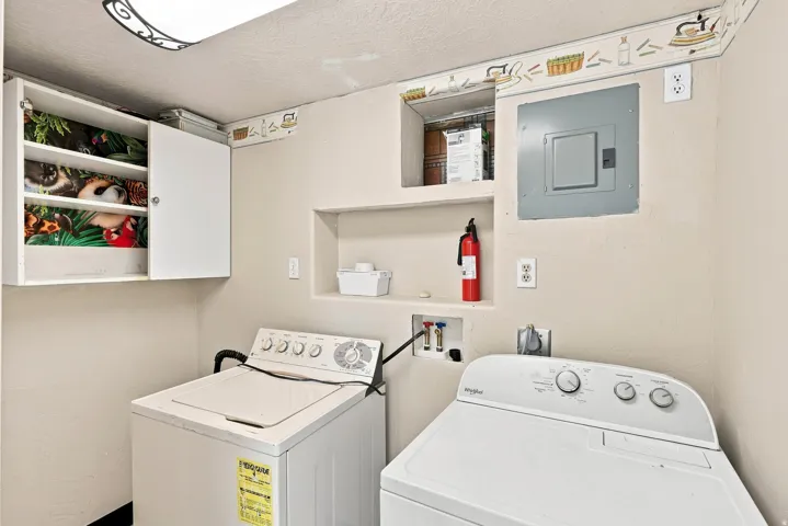 Wall-mounted cabinetry, built-in shelving, and installed laundry hookups
