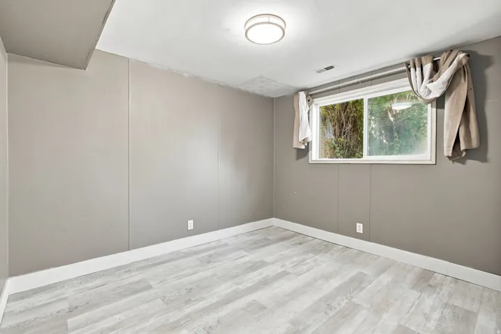Recessed window, wood-finish flooring, flush mount ceiling light, neutral wall paneling, white trim
