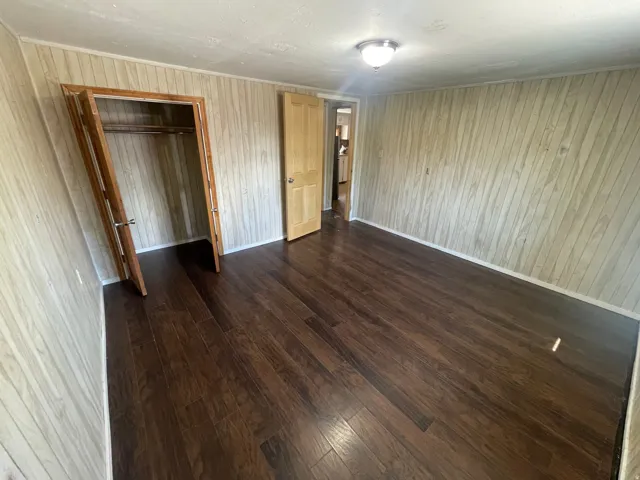 Wood-finish flooring, light wood paneling, wood-finish interior doors, and a ceiling-mounted light fixture