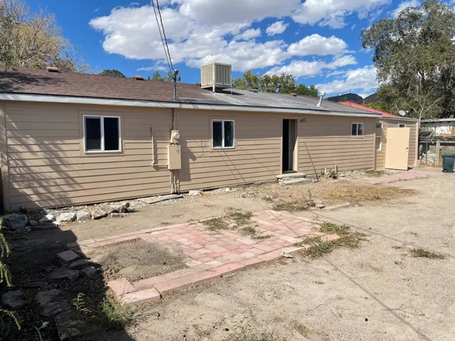 Tan horizontal siding exterior with multiple windows and a brown shingle roof