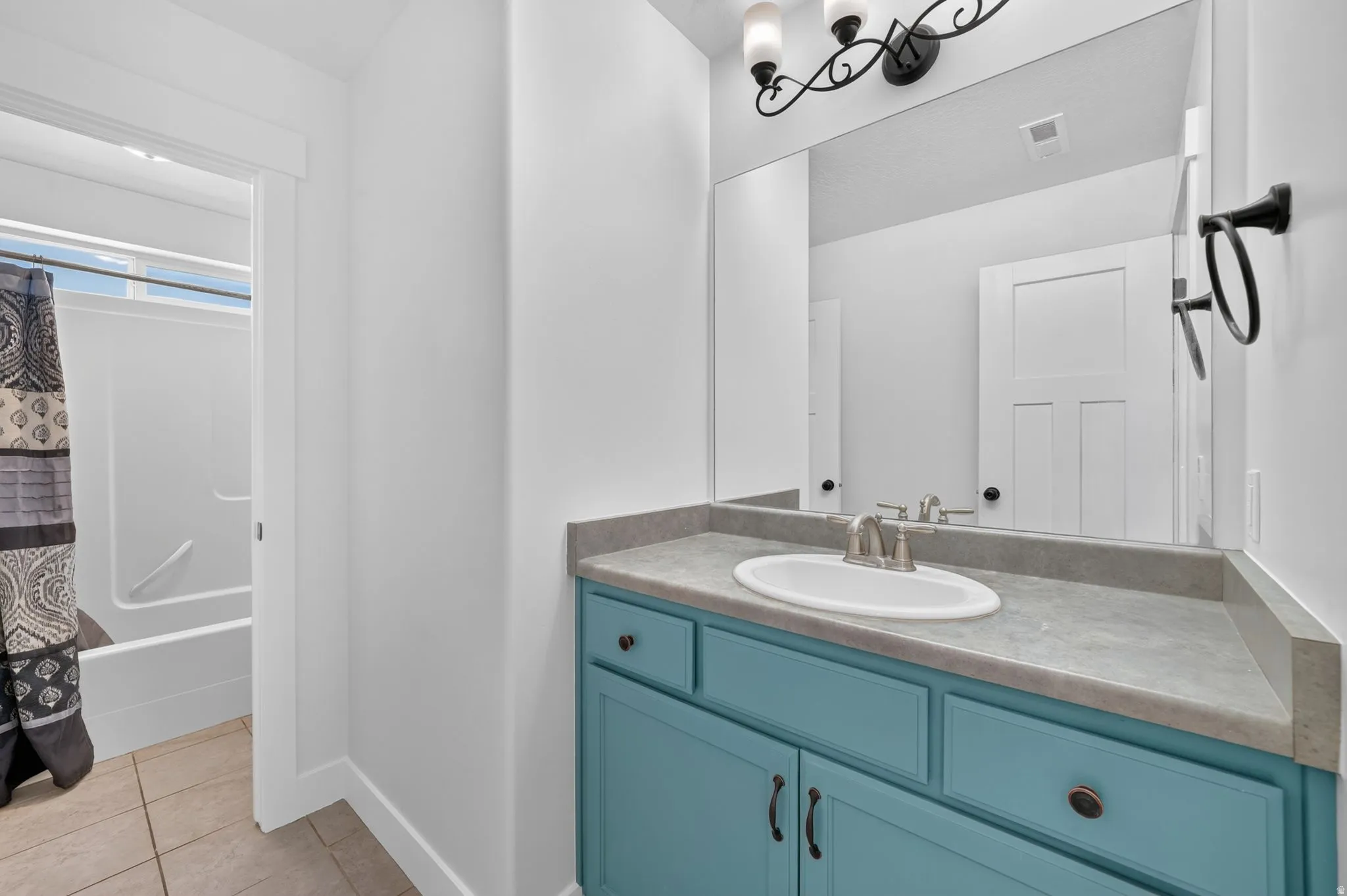Vanity with blue cabinetry, undermount sink, and brushed nickel faucet