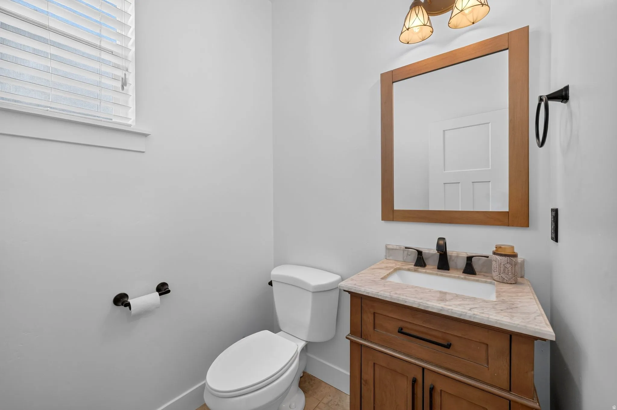 Wood-finish vanity with an integrated sink and stone countertop