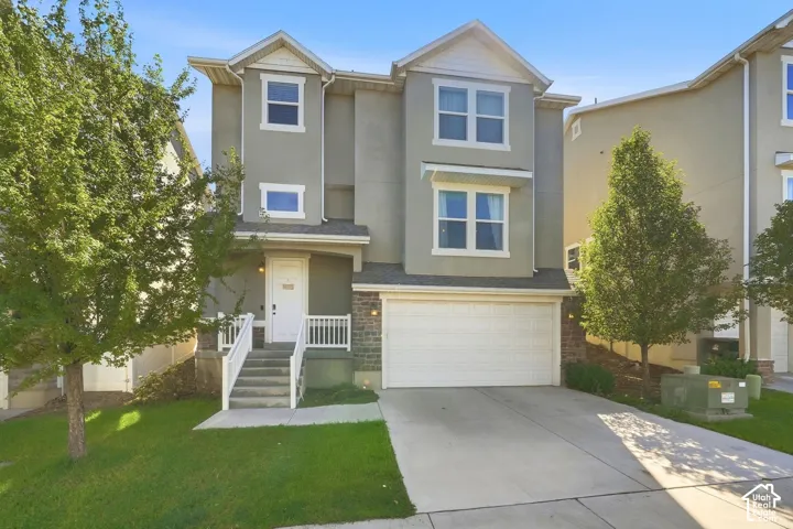 Multi-story stucco exterior with decorative gables, stone accents, and an attached garage