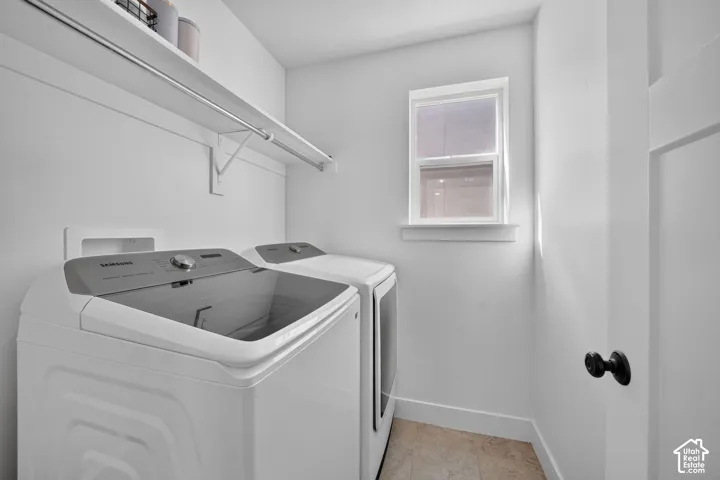 Utility room featuring white walls, a single window, an overhead shelf, a hanging rod, and light-toned floor tiling