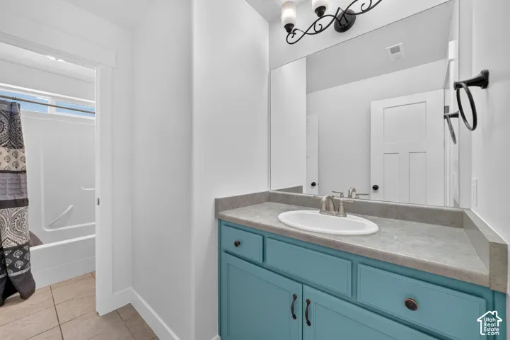 Vanity with blue cabinetry, undermount sink, and brushed nickel faucet