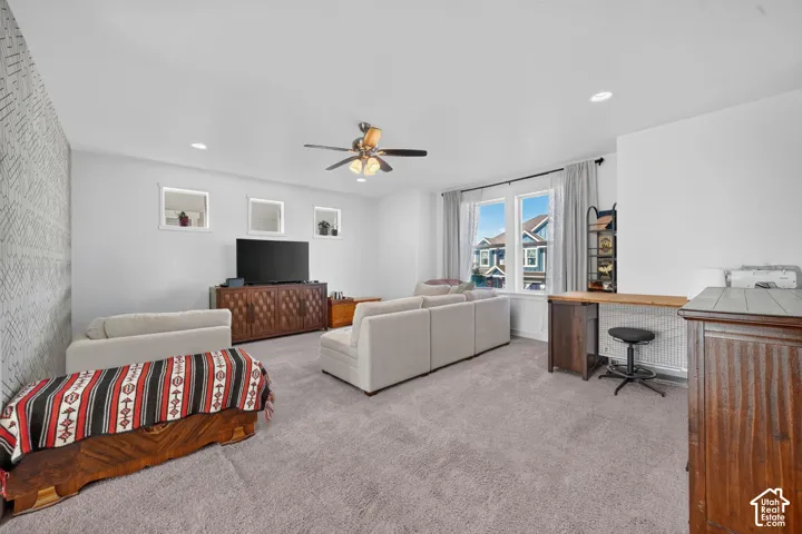 Recessed lighting, ceiling fan, carpeting, built-in desk, and window with exterior view