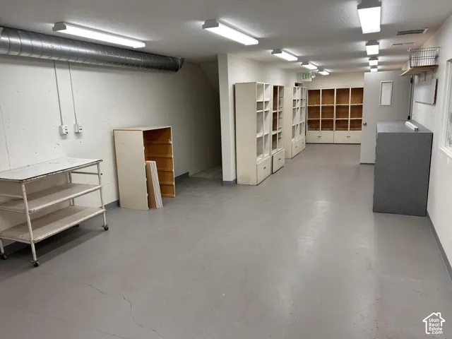 Room with painted walls, multiple overhead lighting fixtures, and light gray flooring