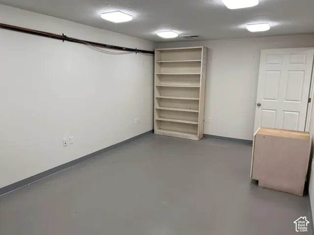 Room with painted walls, multiple overhead lighting fixtures, and light gray flooring