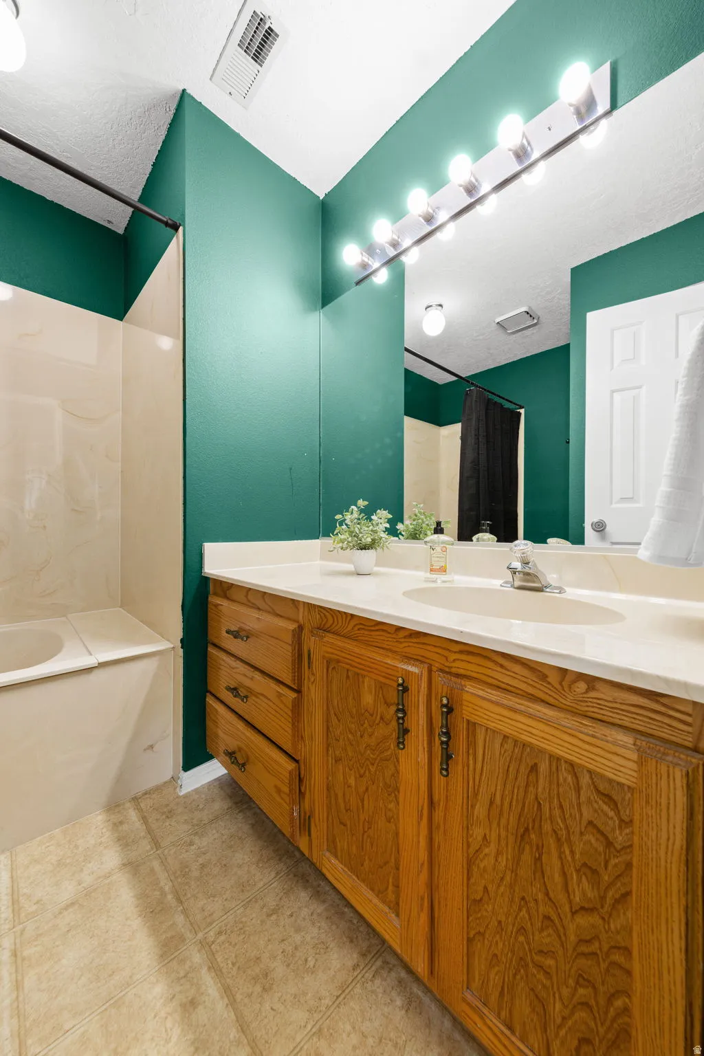 Wood-finish vanity with integrated sink, a large wall mirror.