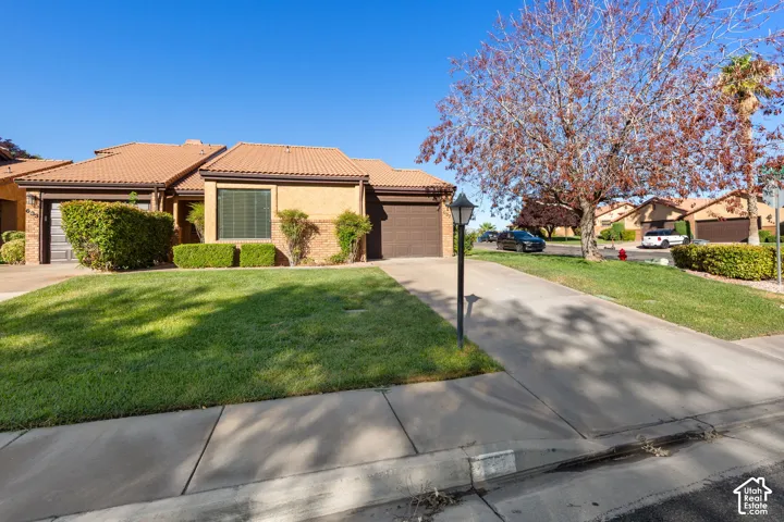 Property exterior with roof tiles, stucco finish, and an attached garage