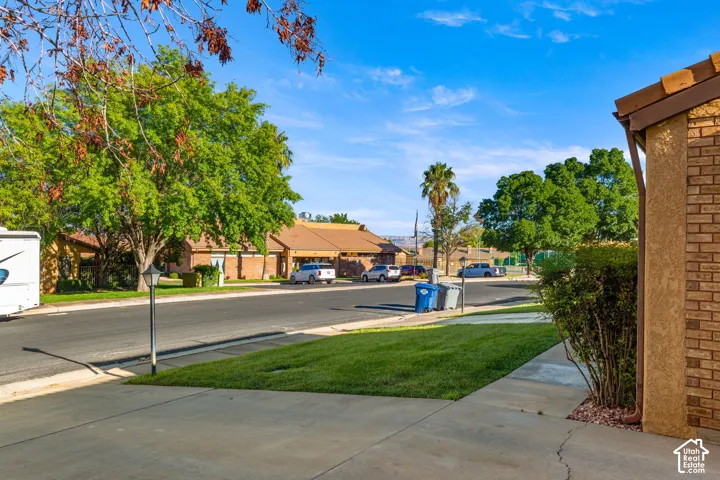 Manicured front lawn with mature trees and concrete walkways