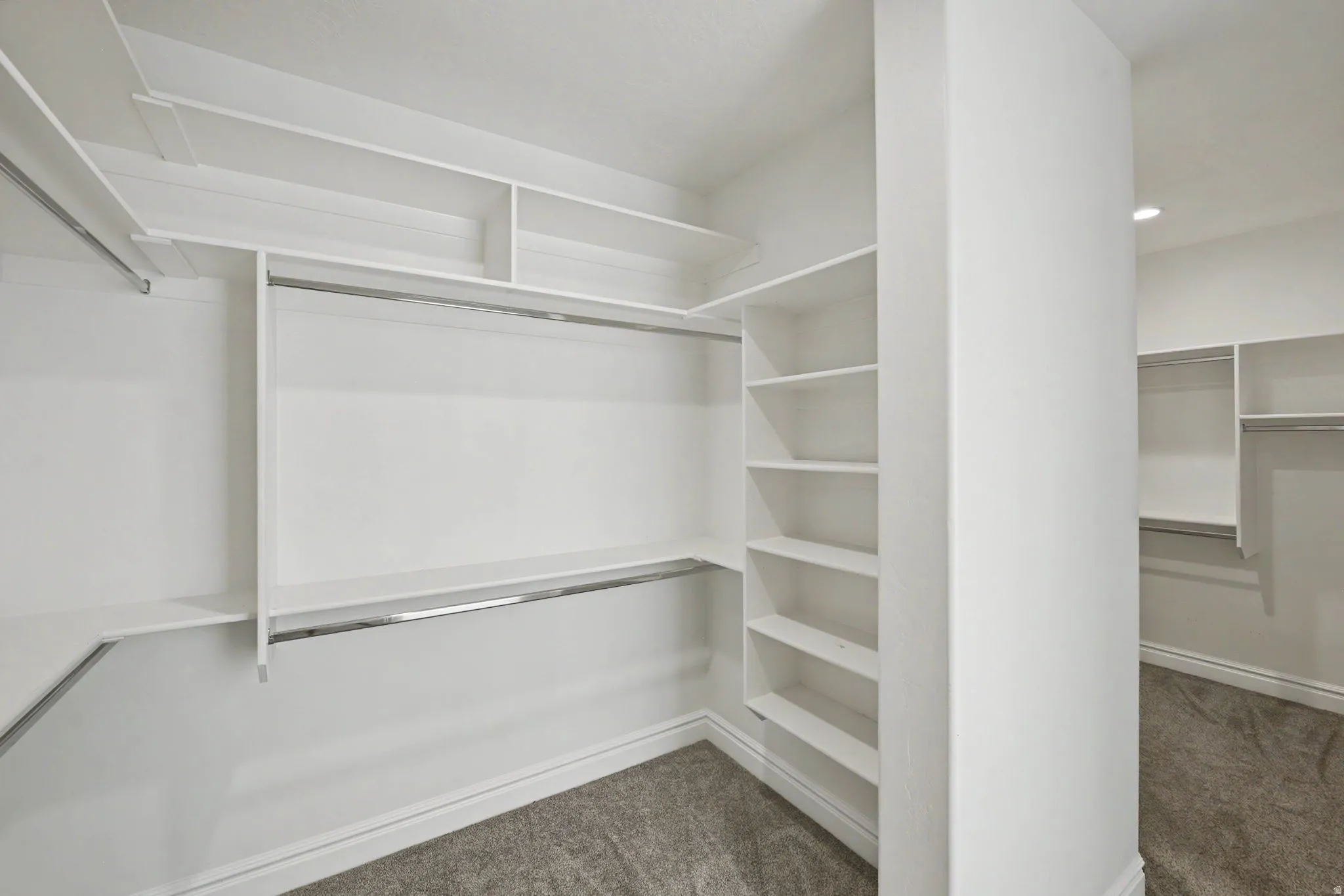 Custom closet system featuring multiple shelving units and chrome hanging rods