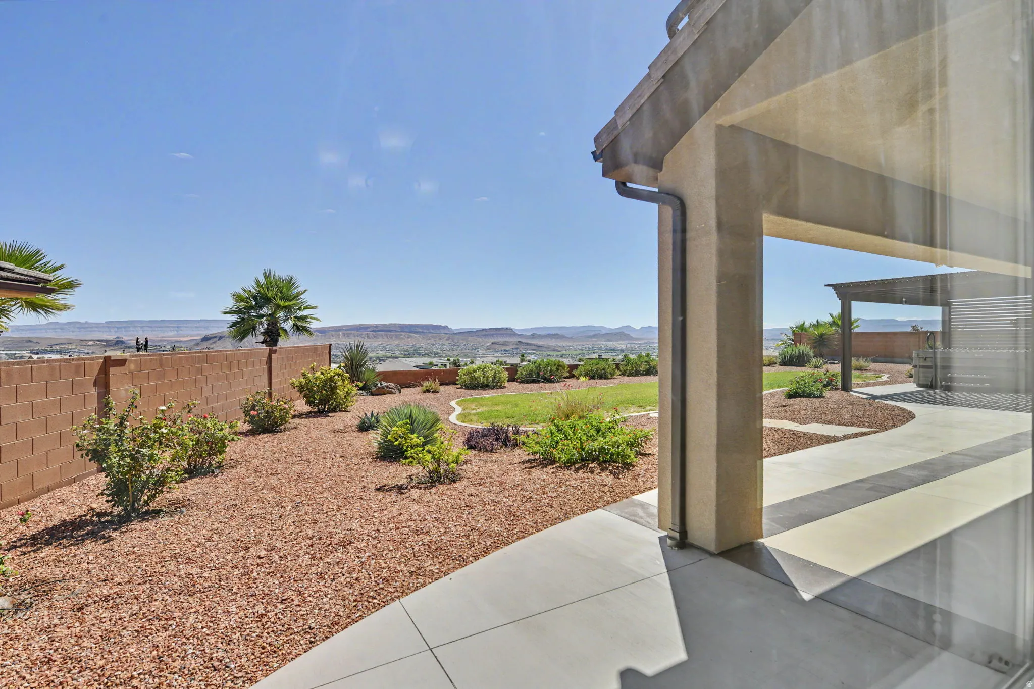 Covered patio with concrete flooring, stucco exterior, and rain gutter system