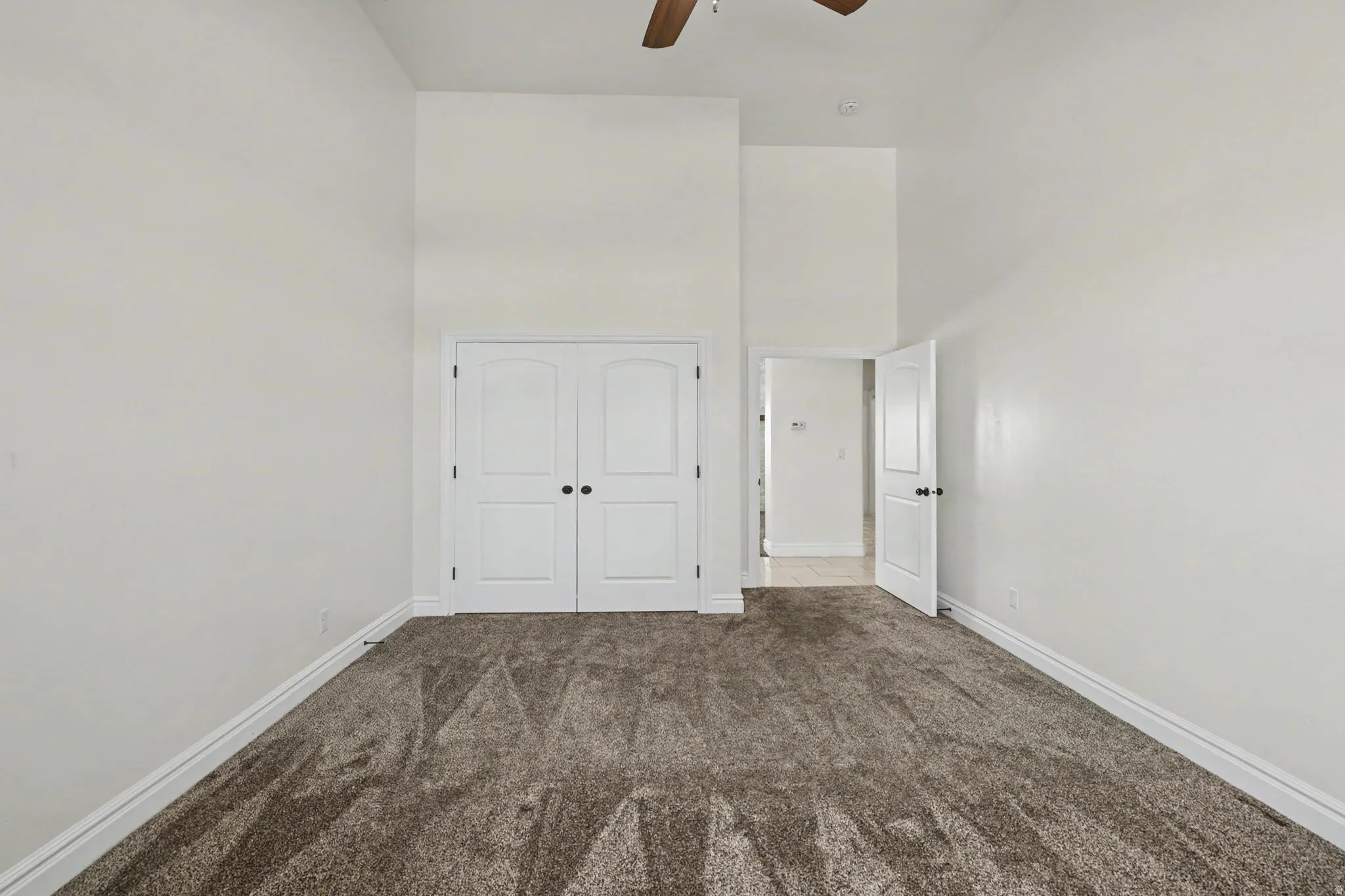 Neutral paint finishes, vaulted ceiling, dual closet doors, and broad carpeting