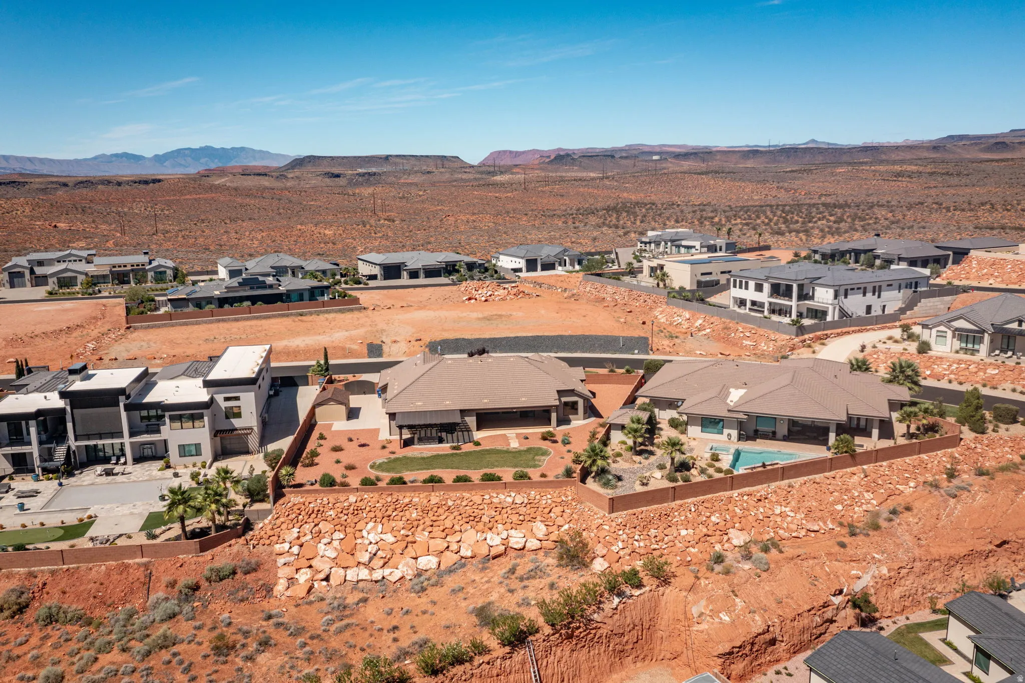 Residential neighborhood featuring diverse architectural styles, mature desert landscaping, and a clear desert sky