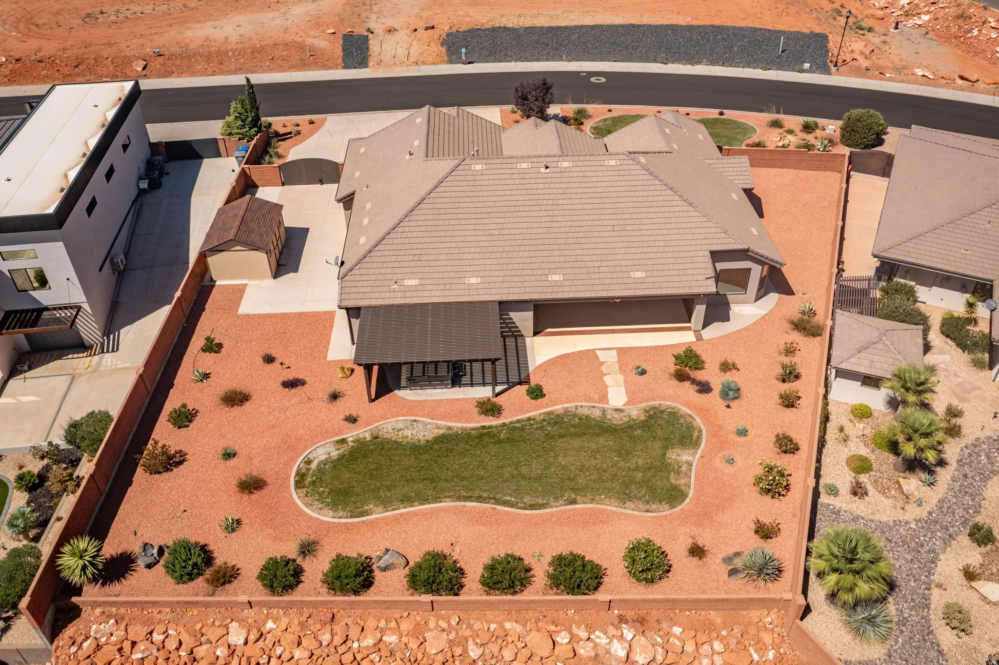 Private backyard with a covered patio, a shaped lawn area, and a storage shed