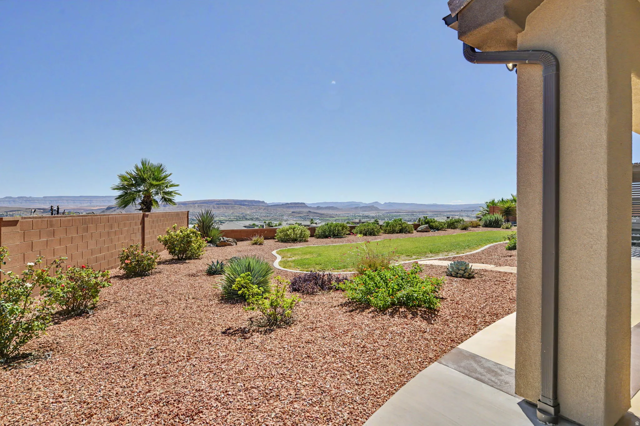Expansive backyard featuring a manicured lawn, established landscaping, and a block wall perimeter