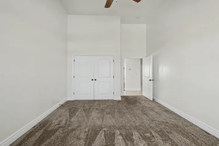 Neutral paint finishes, vaulted ceiling, dual closet doors, and broad carpeting
