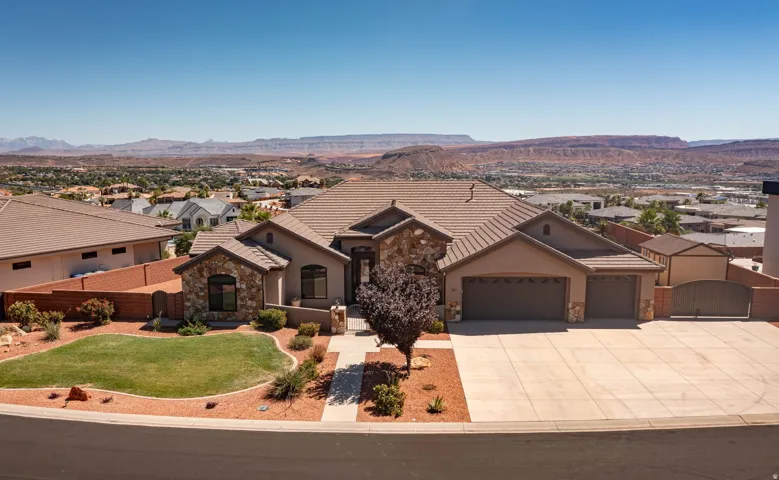 Stucco exterior with stone accents, a tile roof, an attached three-car garage, and a concrete driveway