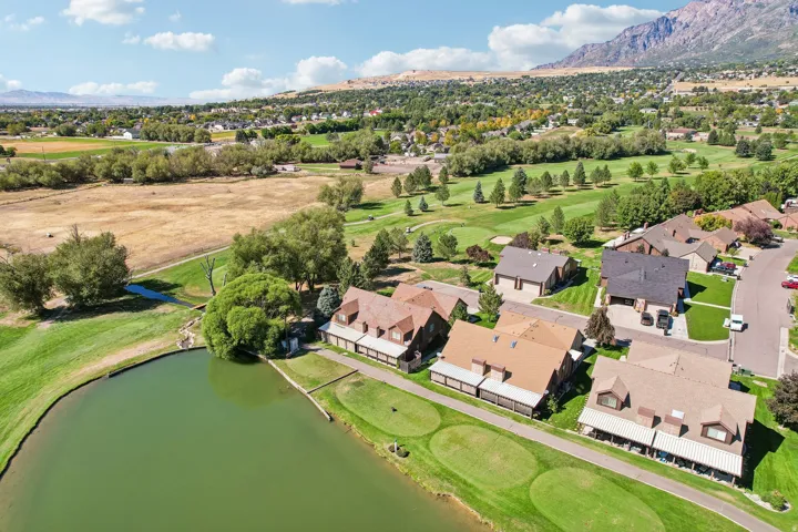 Residential properties with golf course frontage, water features, and mountain backdrop