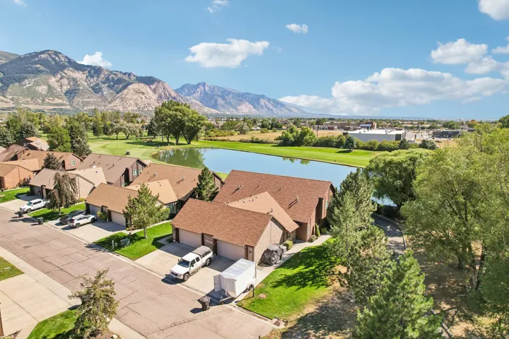 Residential property with a multi-car garage, mature landscaping, and a sloped roofline