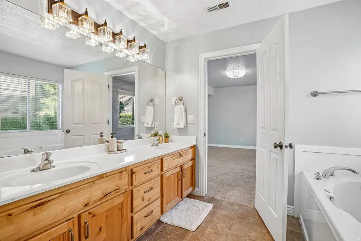 Dual sink vanity with wood cabinetry and white countertop