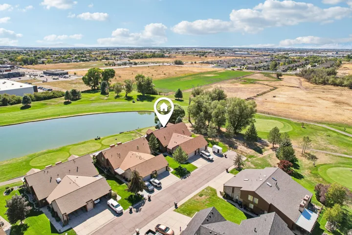 Aerial perspective highlighting golf course frontage, a tranquil water feature, and expansive surrounding green spaces