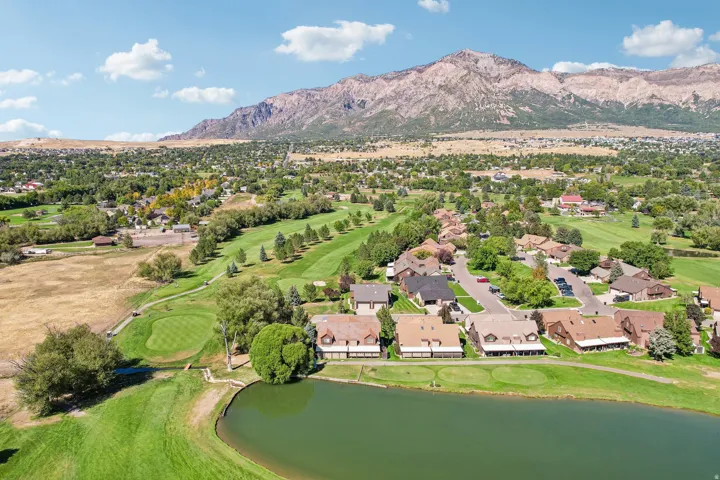 Residential community with mountain backdrop, adjacent to a golf course and water features