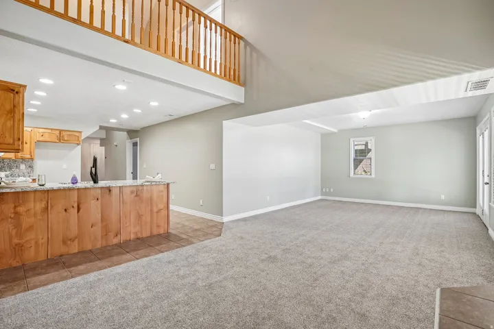 Vaulted ceiling great room with carpet flooring