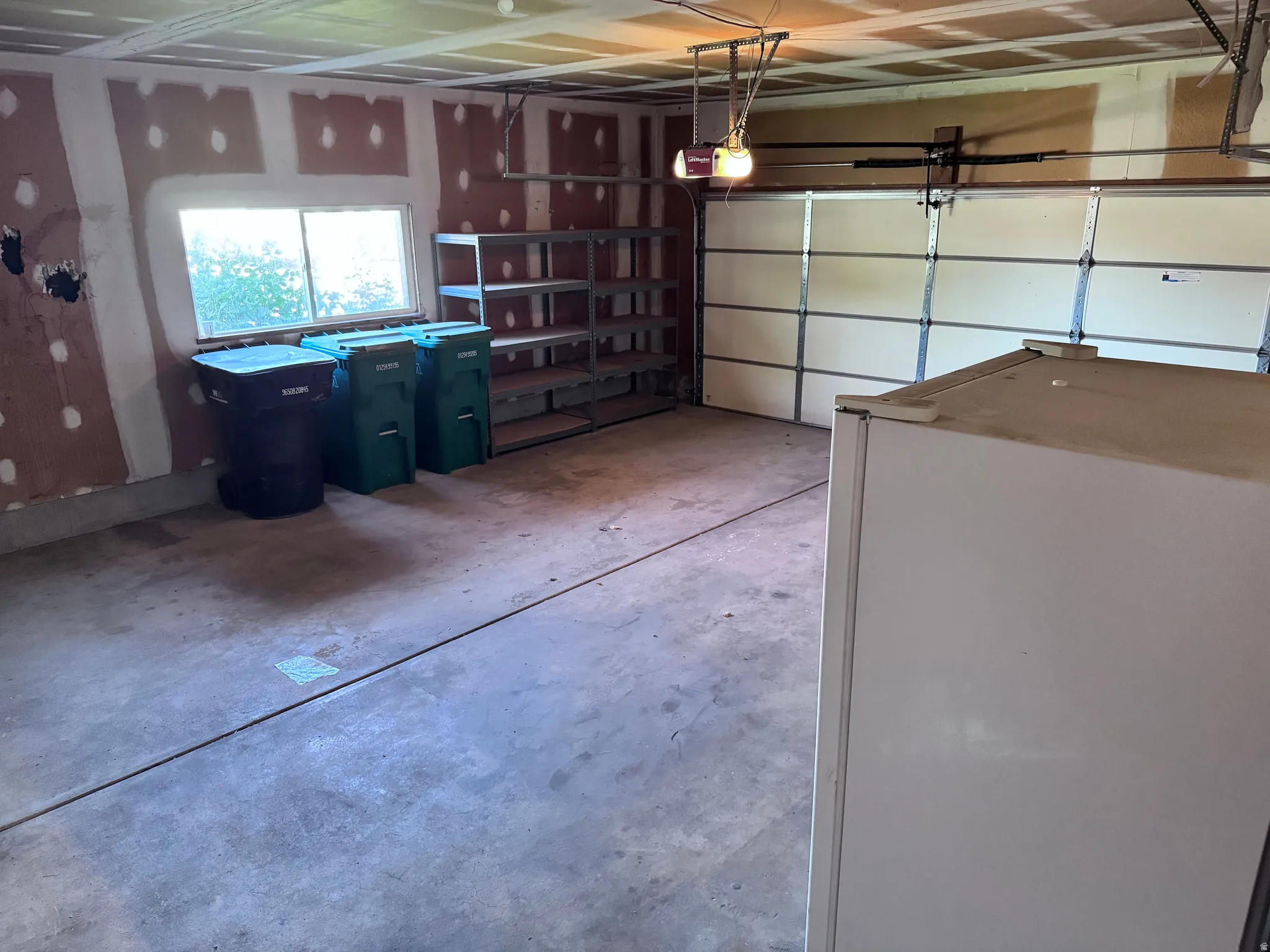 Concrete flooring, exposed ceiling joists, and a single window