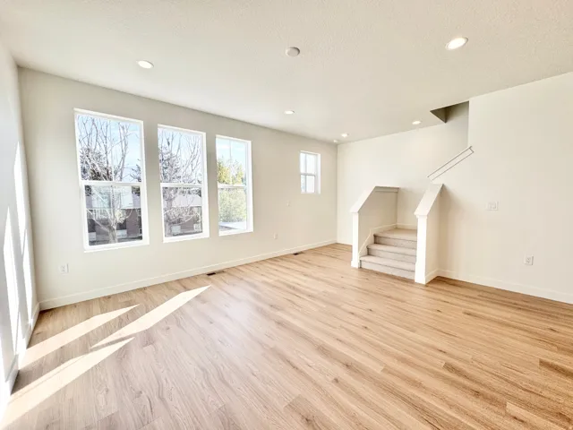 Wood-finish flooring, recessed lighting, multiple windows, and carpeted staircase