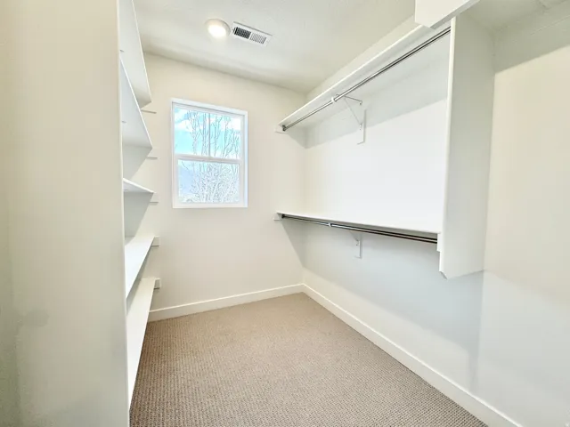 Built-in shelving, hanging rods, recessed lighting, and a window