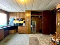 Wood-panel walls with built-in shelving and a window. Bedroom located in the manufactured home.