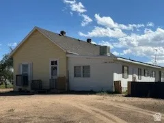 House exterior with yellow siding and connected trailer white siding.