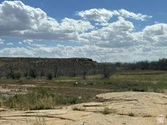 Expansive undeveloped land featuring varied terrain and natural vegetation under a wide-open sky