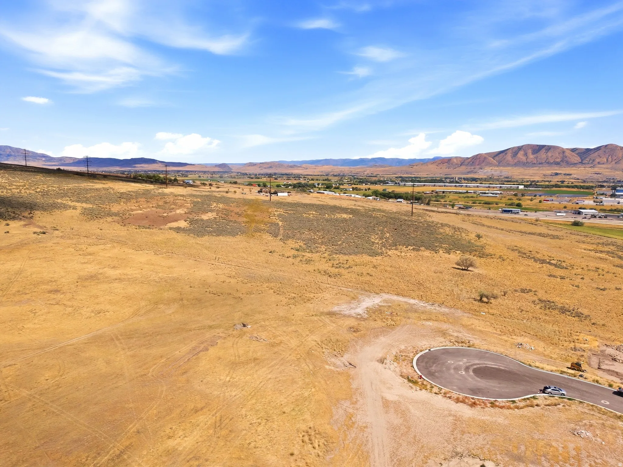 Expansive land lot featuring a paved cul-de-sac and distant mountain backdrop