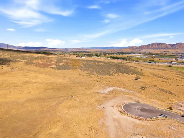 Expansive land lot featuring a paved cul-de-sac and distant mountain backdrop