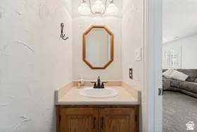 Vanity featuring a built-in sink, wood-finish cabinetry, and an octagonal framed mirror