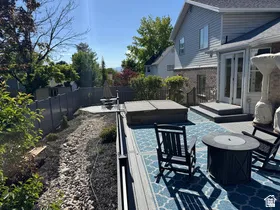 Expansive outdoor deck with a built-in spa, composite decking, and dual exterior doors