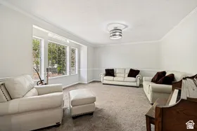 Expansive room featuring multiple large windows, crown molding, and wainscoting