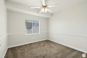Recessed lighting, wall-to-wall carpeting, ceiling fan, window with white trim, and chair rail molding
