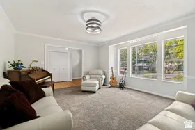 Living area with broad windows, crown molding, and recessed lighting
