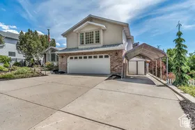 Stucco and brick exterior with a multi-pane window, attached garage, and a covered carport structure