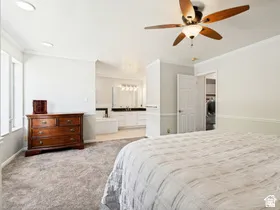 Recessed lighting, ceiling fan, carpet flooring, dual windows, and an en-suite bathroom with a built-in tub and double vanity