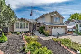 Brick and stucco exterior, two-car garage, bay window, landscaped front yard with decorative curbing, and a prominent entry