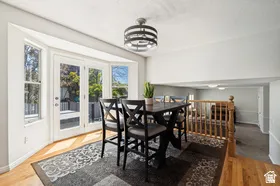 Bay window with double doors, wood-finish flooring, and a contemporary ceiling fixture