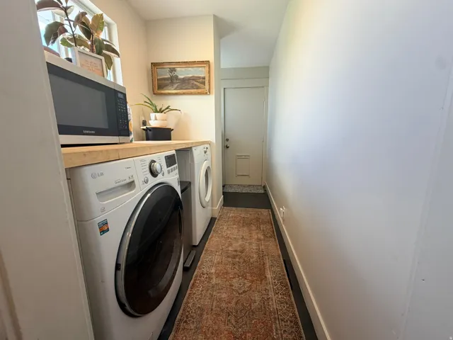Built-in wood-finish countertop with white front-load washer and dryer
