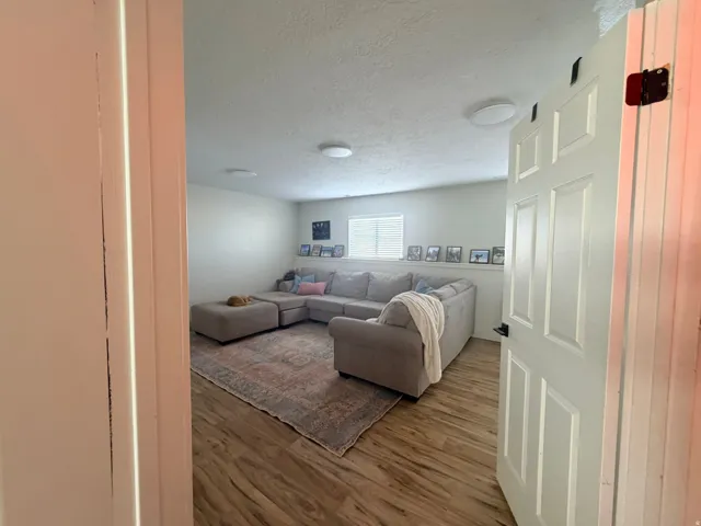 Wood-finish flooring with white baseboards and neutral wall tones